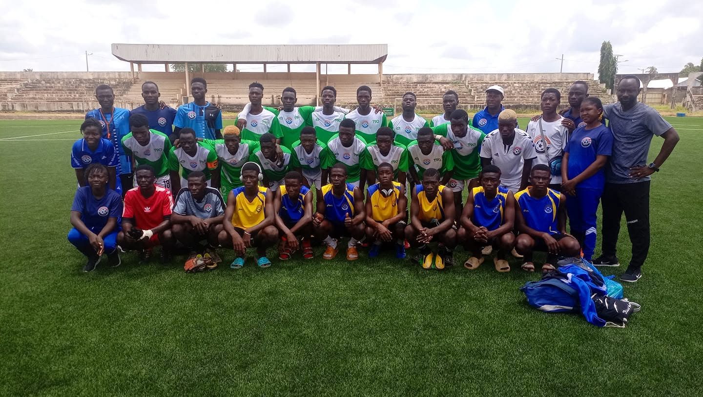 Photo de groupe des joueurs et de l’encadrement sur la pelouse d’un stade