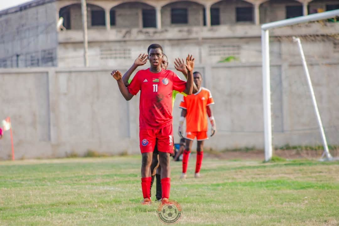 Un joueur de Solingobou FC, en rouge, lève les bras pendant le match U17 contre l’ASE